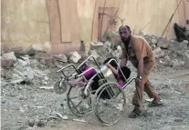  ?? Maya Alleruzzo / AP Photo ?? A man pushes two children as they flee fighting between ISIL and Iraqi special forces in Mosul.