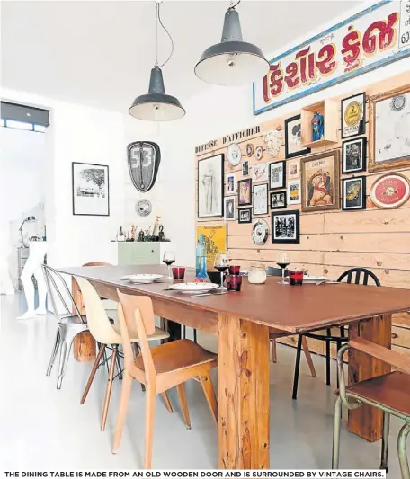  ??  ?? THE DINING TABLE IS MADE FROM AN OLD WOODEN DOOR AND IS SURROUNDED BY VINTAGE CHAIRS.