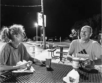  ?? DAVID GOLDMAN/AP ?? Cassidy Scott and her father, Scott, laugh over burgers in Appleton, Wis. They don’t see eye to eye on President Trump.