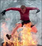  ??  ?? Hot pants: A competitor gets fired up as he hurdles over a wall of flames