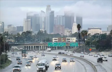  ?? Irfan Khan Los Angeles Times ?? COMMUTERS NAVIGATE the 10 Freeway outside downtown Los Angeles on Thursday morning as the first of an expected trio of storms moved into Southern California. “The best advice would just be to slow down,” CHP Officer Alex Rubio said of driving during...