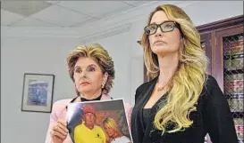  ?? REUTERS ?? Lawyer Gloria Allred (left) on Saturday holds a photograph of Jessica Drake and Donald Trump, taken in 2006 at a golf tournament in Lake Tahoe, California.