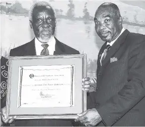  ?? FILE ?? In this November 2007 photo, former Prime Minister P.J. Patterson (left) accepts a plaque from Lloyd Tomlinson, president of the Rusea’s Old Students’ Associatio­n, for the Hanover-based school.