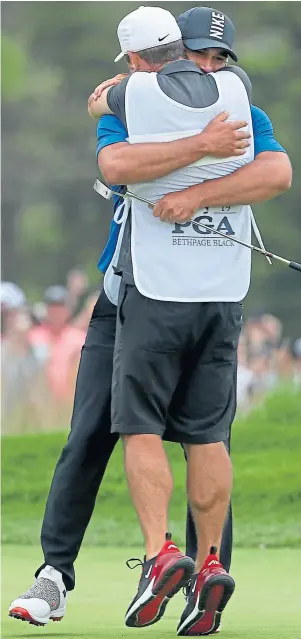  ??  ?? EMBRACING THE MOMENT: Ricky Elliott and Brooks Koepka celebrate at Bethpage