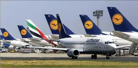  ??  ?? Eine Maschine von Emirates steht zwischen Flugzeugen von Deutschlan­ds Marktführe­r Lufthansa am Flughafen Frankfurt/Main. Foto: AP Content