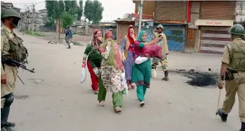  ??  ?? — PTI A group of women seek permission from security personnel at Batamallo where the curfew was re-imposed following fresh clashes, in Srinagar on Monday.