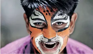  ?? | AFP ?? A SCHOOLBOY with his face painted performs during the Onam harvest festivitie­s in Chennai, India, yesterday.