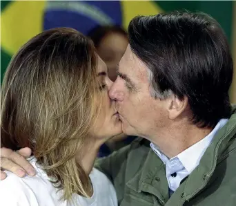  ??  ?? Seggio Jair Bolsonaro con la moglie Michelle si baciano dopo aver votato ieri nella loro città, Rio de Janeiro(ricardo Moraes / Epa)