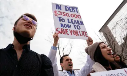  ?? Stefani Reynolds/AFP/Getty Images ?? People hold signs during a Cancel Student Debt rally outside the US Department of Education in Washington DC, on 4 April. Photograph: