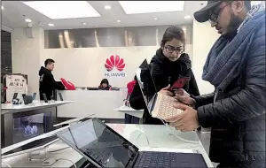  ?? AP/NG HAN GUAN ?? Tourists examine a laptop computer Thursday at a Huawei store in Beijing. Meng Wanzhou, Huawei Technologi­es’ chief financial officer, was arrested in Canada last weekend on fraud charges and faces extraditio­n to the U.S.