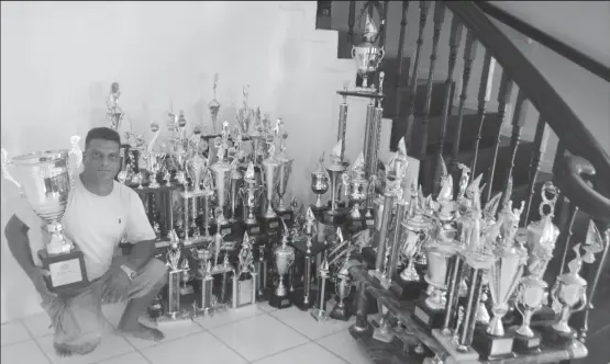  ??  ?? Bartica Regatta champion Dave Persaud with his numerous trophies.