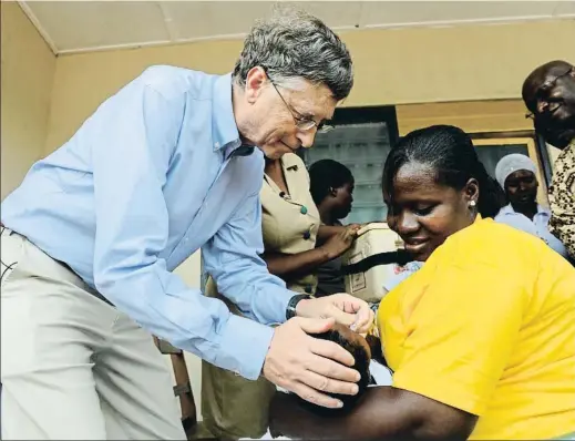  ?? PIUS UTOMI EKPEI / AFP ?? Bill Gates le da a un niño una vacuna de rotavirus contra la diarrea en un centro sanitario de Ghana