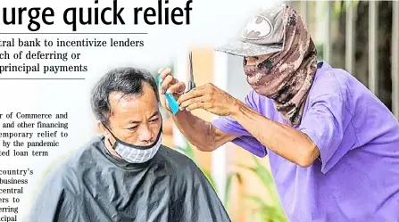  ??  ?? STREET barber cuts hair for a customer. Government help is pivotal for small entreprene­urs to get back on the business groove.