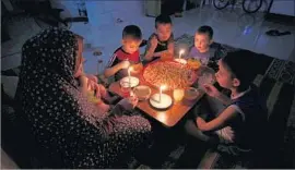  ?? Said Khatib AFP/Getty Images ?? FOR PALESTINIA­NS in Gaza, who are no strangers to the territory’s chronic power outages, it is dinner by candleligh­t in the Rafah refugee camp.