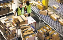  ?? Ross D. Franklin / Associated Press ?? Employees organize outbound packages at an Amazon.com fulfillmen­t center in Phoenix.