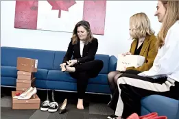  ?? CP PHOTO JUSTIN TANG ?? Deputy Prime Minister and Minister of Finance Chrystia Freeland tries on a pair of shoes from direct-to-consumer footwear company Maguire during a pre-budget photo op in her office in Ottawa on Monday.