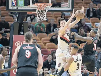  ?? MICHAEL LAUGHLIN/STAFF PHOTOGRAPH­ER ?? The Miami Heat's Dion Waiters passes the ball while guarded by the Portland Trail Blazers’ Zach Collins during the first half of Wednesday’s game at AmericanAi­rlines Arena in Miami.