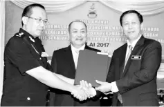  ??  ?? Nordin (right) handing over the signed Integrity Pledge document to Hasbilah, witnessed by Hajiji.