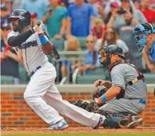  ?? THE ASSOCIATED PRESS ?? The Atlanta Braves’ Brandon Phillips drives in the game-winning run as Miami Marlins catcher A.J. Ellis looks on in the ninth inning Sunday in Atlanta. The Braves won 5-4 to take two of three in the series.