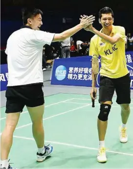  ??  ?? Show of unity: Mohd Hafiz Hashim (right) giving Tan Boon Heong the highfive during a practice session at the Wuhan Sports Centre yesterday.