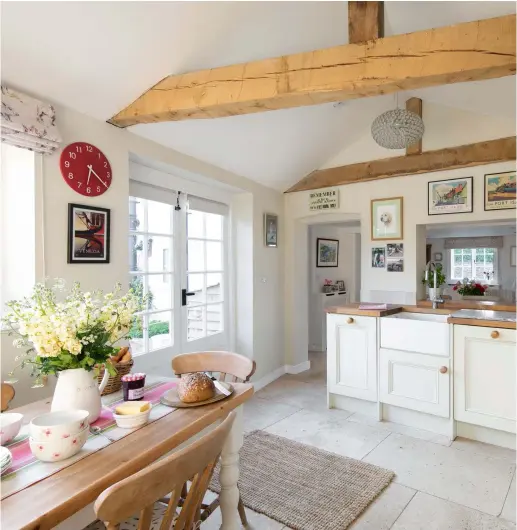  ??  ?? Above: To enhance the rustic feel of the kitchen, the couple tracked down a farmhouse-style table from Victoriana in Southsea. The table runner was a gift from a Swedish friend, and is teamed with Waitrose crockery. The Roman blinds are made in Pigs fabric by Clarke & Clarke. A red clock from John Lewis & Partners adds a splash of colour Right: Judy and Stuart decided to keep the Shaker-style units but add more personalit­y into this space. Cherished pieces of china are displayed on the dresser, the top of which was made by a local carpenter and painted in Farrow & Ball’s Clunch to match the units. They inherited the Aga from the previous owners