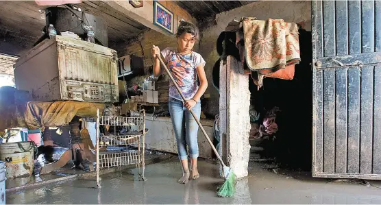  ??  ?? En Culiacán una menor comienza las labores de limpieza en su vivienda tras los efectos de la depresión tropical 19-E.