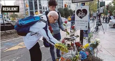  ?? AFP PIC ?? People placing flowers at a memorial at the scene of Tuesday’s terrorist attack along a bike path in Manhattan on Thursday.
RESILIENT