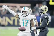  ?? BUTCH DILL/AP ?? Dolphins wide receiver Jaylen Waddle (17) drops the ball in front of Saints cornerback Marshon Lattimore after making a catch on Dec. 27.