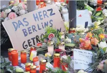  ?? MICHAEL SOHN/ASSOCIATED PRESS ?? A sign reading, “the heart of Berlin was hit,” sits between candles in Berlin, two days after a truck ran into a crowded Christmas market, killing 12 and injuring 48.