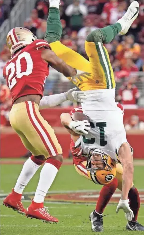  ?? TONY AVELAR/AP ?? Green Bay Packers wide receiver Allen Lazard (13) tumbles to the ground between San Francisco 49ers free safety Jimmie Ward (20) and Emmanuel Moseley during the first half Sunday in Santa Clara, Calif.