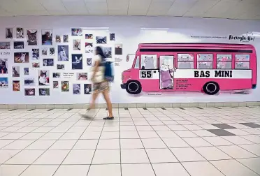  ??  ?? Eye-catching: A commuter walking past a drawing of a pink mini bus, a familiar sight around the streets of Kuala Lumpur in the 1980s and 1990s.