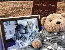  ??  ?? Pictures of Jaxson JudeDement, born stillborn this summer, and a Teddy bear are placed inside a Caring Cradle donated to Atrium Medical Center’s Family Birthing Center by his parents, Joshua and Faith Dement.