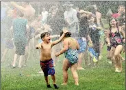  ?? (AP/The Star-Beacon/Warren Dillaway) ?? Water rains down on children Sunday during the Geneva Water Battle at Memorial Field in Geneva, Ohio. Firetrucks provided a cooling opportunit­y for hundreds of people during the annual event.