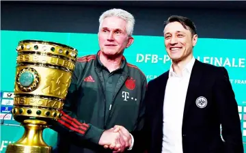  ??  ?? Bayern Munich coach Jupp Heynckes (left) and his Frankfurt counterpar­t Niko Kovac pose next to German Cup DFB Pokal trophy during a joint press conference on the eve of the German Cup at Berlin’s Olympic stadium. — AFP photo