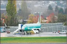  ??  ?? In this file photo, workers stand near a Boeing 737 Max airplane parked at Renton Municipal Airport next to the Boeing assembly facility in Renton,
Washington. (AP)