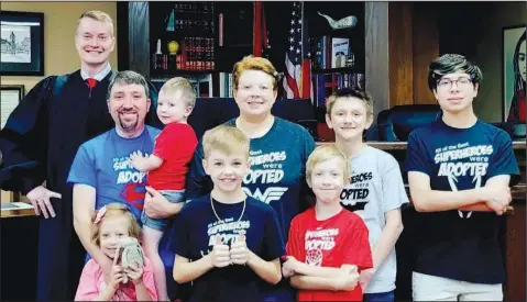  ?? Special to The Saline Courier ?? The Morrises pose during the adoption proceeding for their son Miles. Pictured are, from left, Circuit Judge Robert Herzfeld, and the Morris family: Emmarie, Eric, Andrew, Miles, Libby, Benjamin, Jaxxon and Daniel.