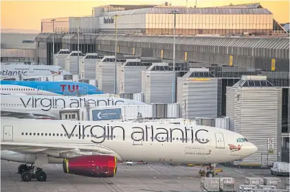  ??  ?? Passenger aircraft, operated by Tui AG and Virgin Atlantic Airways, sit grounded on the tarmac at Manchester Airport on June 1.