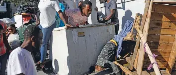  ?? / AP ?? Violencia. Un grupo de personas observa un cadáver tras un tiroteo durante la noche en el vecindario Petion Ville de Puerto Príncipe, Haití, el 18 de marzo de 2024.