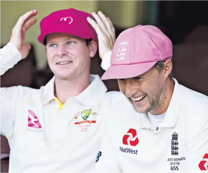  ??  ?? Head boys: Ashes captain Steve Smith and Joe Root wear pink caps to support a breast-cancer charity on Jane Mcgrath Day