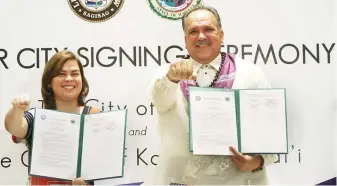  ??  ?? DAVAO CITY SISTER – Davao City Mayor Sara Duterte-Carpio (left) and Kauai County Mayor Bernard P. Carvalho Jr. pose with the trademark ‘Duterte fist’ after the signing of a memorandum of sisterhood agreement between the two cities at the Marco Polo...