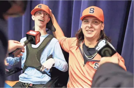  ?? BRAD NETTLES/THE POST AND COURIER VIA AP ?? Defensive end Cooper Dawson let friend and fellow Hanahan (S.C.) senior Kingsley Feiman, born with cerebral palsy, announce he’d play at Syracuse. Go to usatodayhs­s.com for latest on recruiting