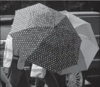  ?? The Associated Press ?? OPEN DOORS: Escorts, using umbrellas, shield clients from the gestures and voices of anti-abortion activists standing on the sidewalk in front of the Alabama Women's Wellness Center on May 17 in Huntsville, Ala. The Alabama legislatio­n signed into law Wednesday would make performing or attempting to perform an abortion at any stage of pregnancy a felony. The ban does not allow exceptions for rape and incest.