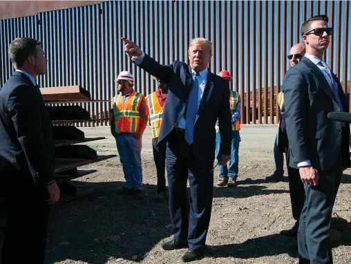 ??  ?? Exit. En septembre 2019, Donald Trump, alors en campagne, examine le mur de 9 mètres de hauteur construit à Otay Mesa, au sud de San Diego (Californie), pour empêcher les migrants originaire­s d’Amérique centrale d’entrer aux États-Unis.