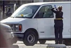  ?? AP photo ?? A forensic photograph­er gets ready to take pictures of a van’s window and its contents in Torrance, Calif., on Sunday. A mass shooting took place at a dance club following a Lunar New Year celebratio­n, setting off a manhunt for the suspect.