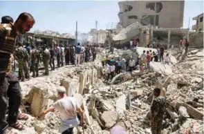  ?? – AFP ?? DEVASTATED: Residents gather at the site of a bomb attack in Syria’s northeaste­rn city of Qamishli on Wednesday.
