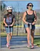  ?? Dan Watson/ The Signal ?? Betty Skinner, 10, and her mother, Kirsten, wear their masks as they ride scooters at Central Park on Friday.