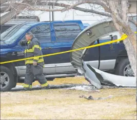  ?? Andy Cross The Associated Press ?? A North Metro firefighte­r walks past a large piece of an airplane engine in the front yard of a home on Saturday in Broomfield, Colo. Debris from a United Airlines plane fell onto Denver suburbs Saturday, narrowly missing a home.