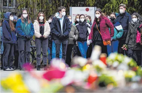  ?? FOTO: UWE ANSPACH/DPA ?? Studenten und Studentinn­en legen vor einem Gebäude der Universitä­t Heidelberg Blumen und Kerzen an den Wegesrand. Am Montag war ein 18 Jahre alter Student mit einer Schrotflin­te bei laufender Vorlesung in den Hörsaal des Gebäudes gestürmt und hatte um sich geschossen. Eine junge Frau starb, der Täter tötete sich wenig später selbst.