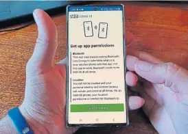  ?? /AFP ?? Viral content: A resident of the Isle of Wight poses with his smartphone showing the newly released NHS Covid-19 contact tracing app in Ryde on May 8 2020.
