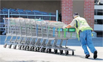  ?? JOE BURBANK/ORLANDO SENTINEL ?? With temperatur­es in the low 90s, gathering shopping carts feels more like a summer task for a Walmart worker at a store in Orlando on Monday. Another hot day today will match the record for the driest March in the history of the city.